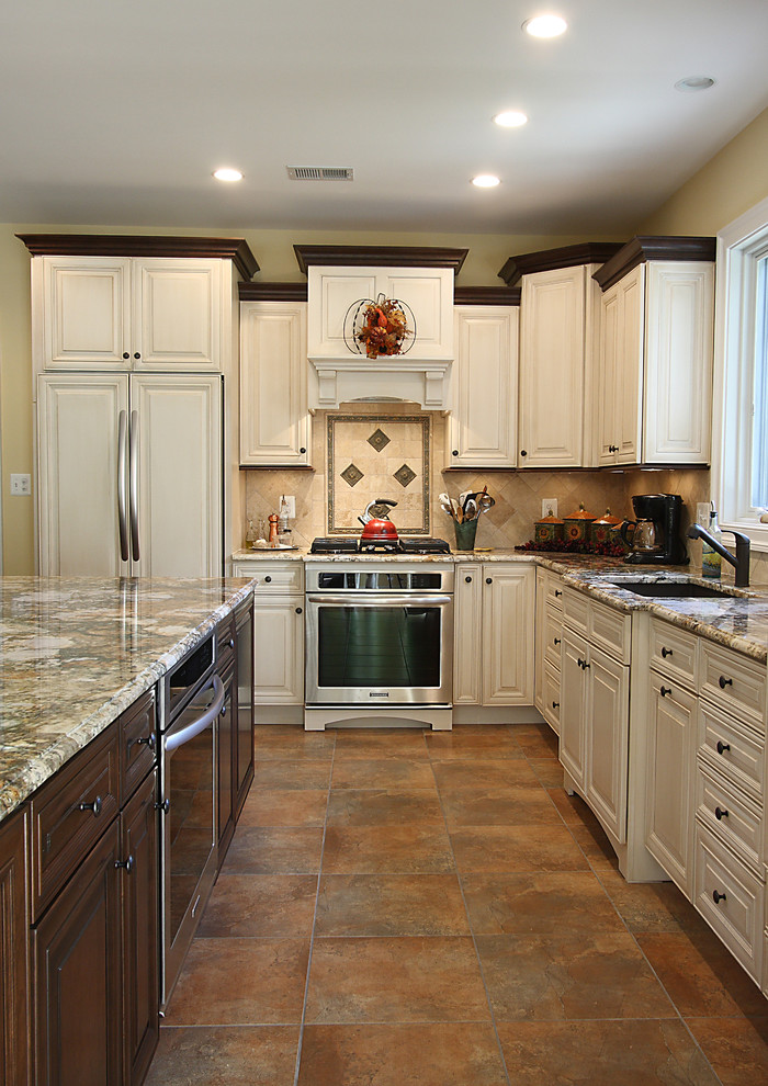 Immagine di una cucina classica con lavello sottopiano, ante con bugna sagomata, ante beige, paraspruzzi beige e elettrodomestici da incasso