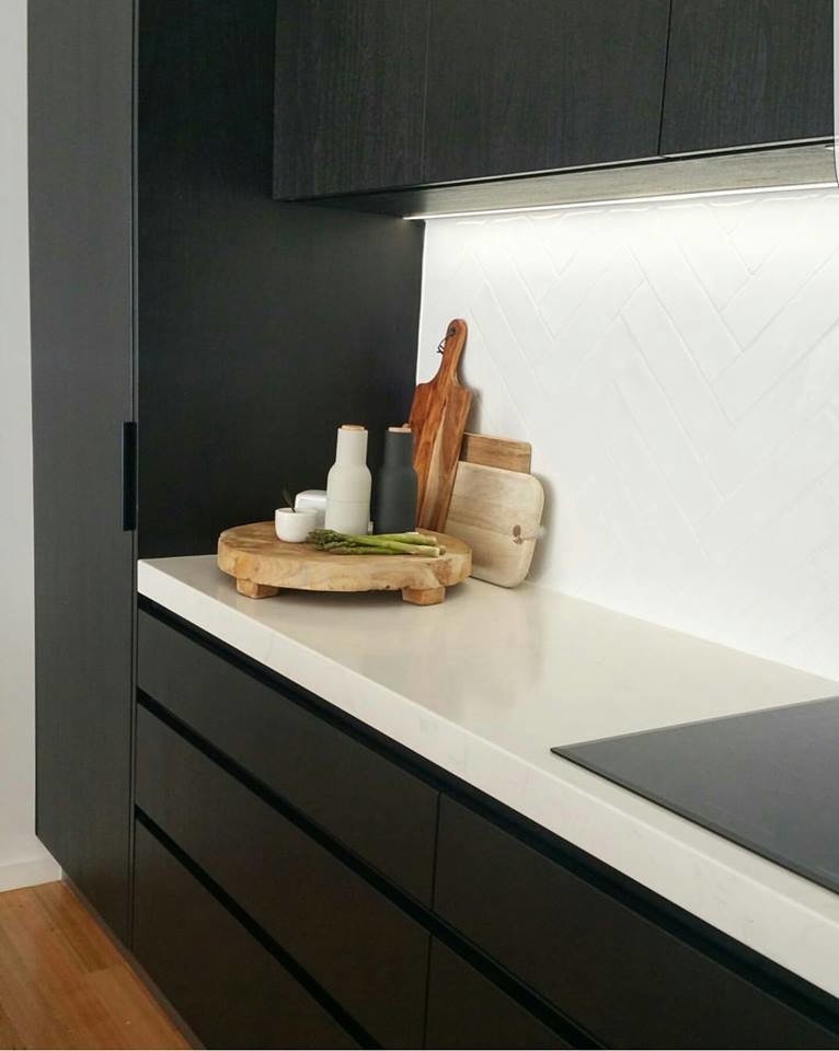 Foto di una cucina nordica con ante nere, top in quarzo composito, paraspruzzi bianco, paraspruzzi con piastrelle in ceramica, pavimento in legno massello medio e elettrodomestici in acciaio inossidabile