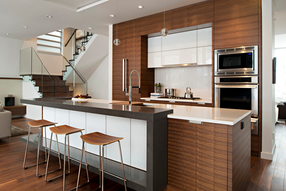 Immagine di una cucina design con lavello sottopiano, ante lisce, ante in legno bruno, paraspruzzi bianco e paraspruzzi con lastra di vetro