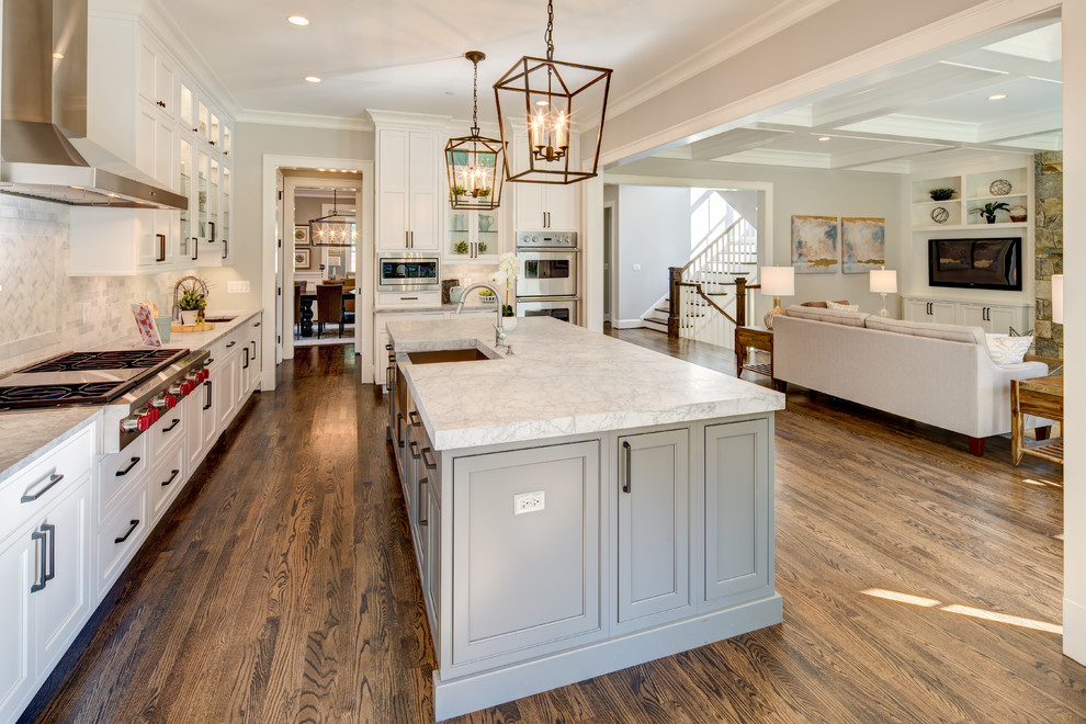 This is an example of a large traditional l-shaped kitchen/diner in DC Metro with a submerged sink, shaker cabinets, white cabinets, granite worktops, grey splashback, marble splashback, stainless steel appliances, dark hardwood flooring, an island, brown floors and grey worktops.