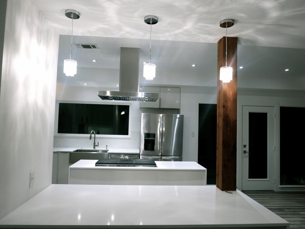 Modern u-shaped open plan kitchen in Dallas with a single-bowl sink, white cabinets, quartz worktops, white splashback, stone tiled splashback, stainless steel appliances, bamboo flooring and an island.