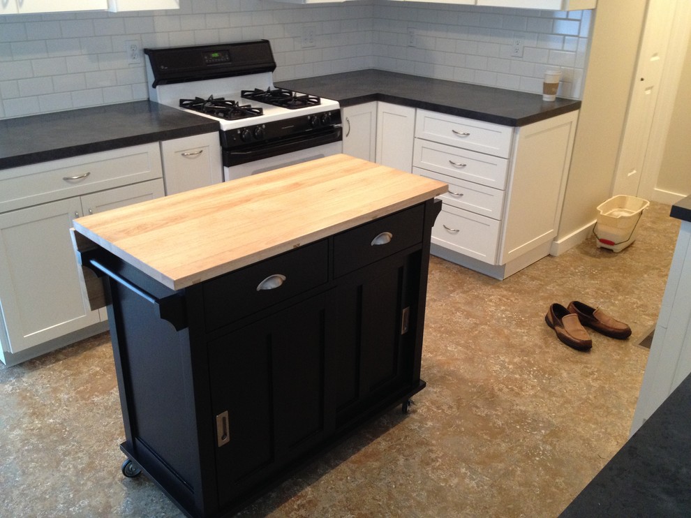 Small transitional galley linoleum floor eat-in kitchen photo in Grand Rapids with a double-bowl sink, raised-panel cabinets, white cabinets, laminate countertops, white backsplash, subway tile backsplash, white appliances and an island