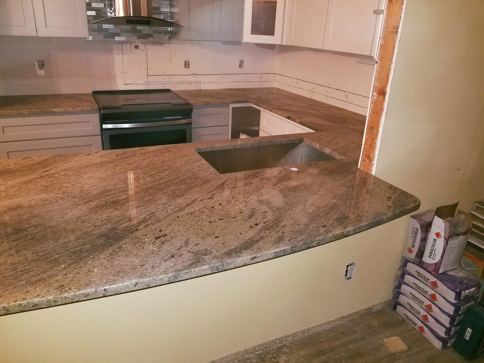 Esempio di una cucina minimalista di medie dimensioni con lavello a vasca singola e top in granito