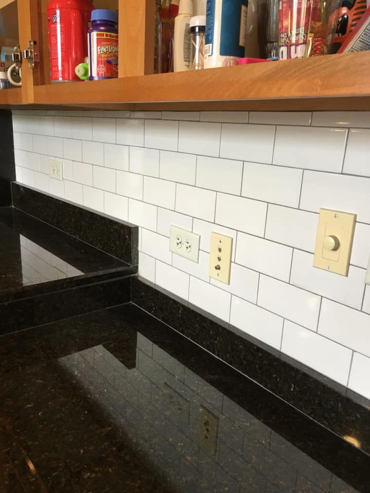 Esempio di una cucina di medie dimensioni con lavello da incasso, top in granito, paraspruzzi nero, pavimento in laminato, nessuna isola, pavimento bianco e top nero