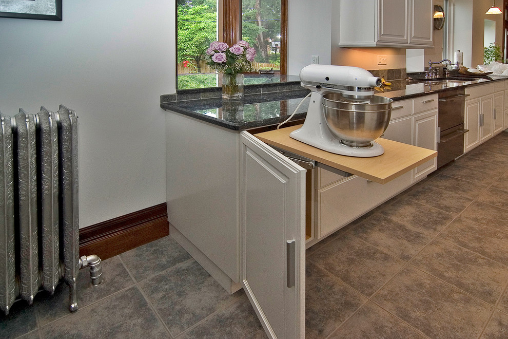 Trendy galley eat-in kitchen photo in St Louis with an undermount sink, raised-panel cabinets, white cabinets, granite countertops, gray backsplash, stone tile backsplash and stainless steel appliances