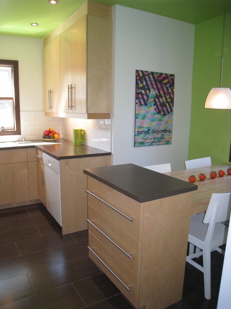 Example of a trendy u-shaped enclosed kitchen design in Montreal with an undermount sink, flat-panel cabinets, light wood cabinets, solid surface countertops, white backsplash, subway tile backsplash and white appliances