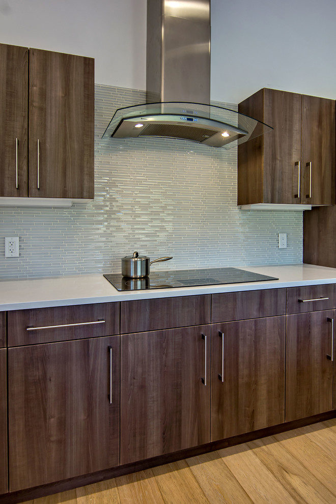 Example of a 1960s single-wall eat-in kitchen design in San Francisco with an undermount sink, flat-panel cabinets, medium tone wood cabinets, quartzite countertops, gray backsplash and stainless steel appliances