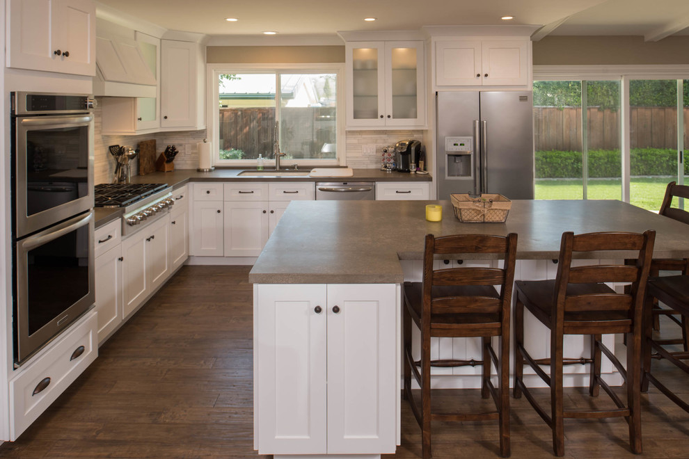 Mittelgroße Moderne Küche in L-Form mit Unterbauwaschbecken, Schrankfronten im Shaker-Stil, weißen Schränken, dunklem Holzboden und Kücheninsel in San Francisco