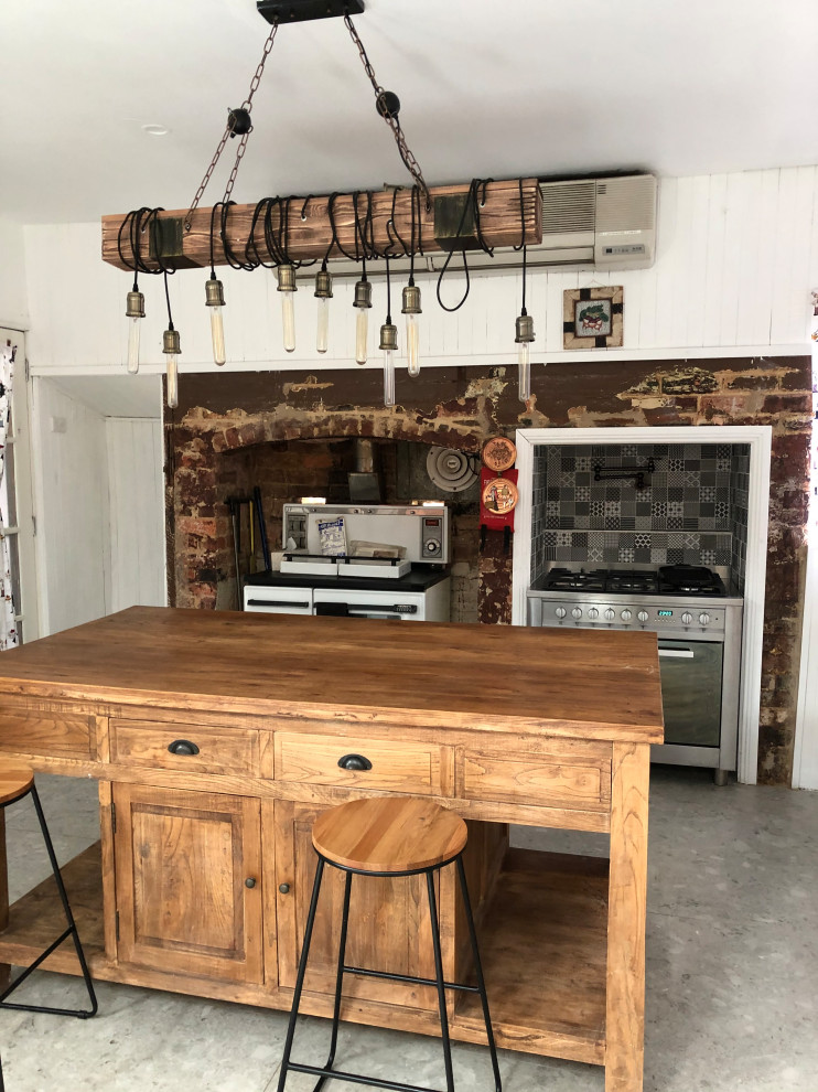 Immagine di un cucina con isola centrale rustico con top in legno, pavimento con piastrelle in ceramica e pavimento grigio
