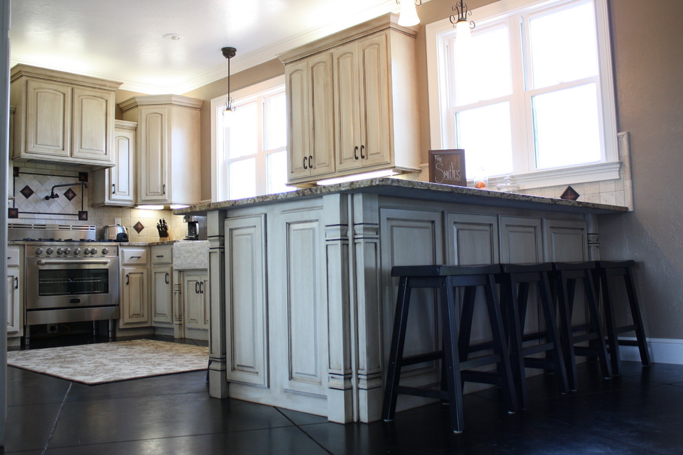 Imagen de cocina de estilo de casa de campo con fregadero sobremueble, puertas de armario con efecto envejecido, encimera de granito y suelo de cemento