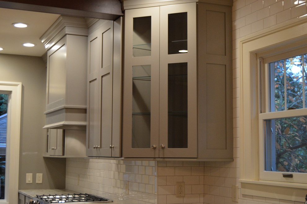 Bild på ett stort funkis kök, med en undermonterad diskho, skåp i shakerstil, grå skåp, marmorbänkskiva, vitt stänkskydd, stänkskydd i tunnelbanekakel, rostfria vitvaror, mellanmörkt trägolv och en köksö
