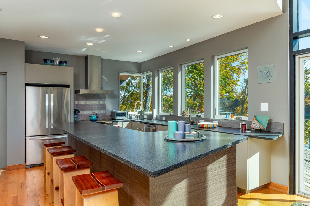 Foto di una cucina costiera con ante lisce, paraspruzzi multicolore, elettrodomestici in acciaio inossidabile, pavimento in legno massello medio e top nero