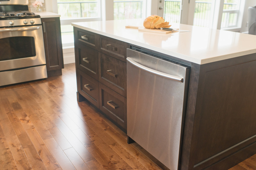 Example of a large trendy u-shaped medium tone wood floor eat-in kitchen design in Vancouver with an undermount sink, shaker cabinets, dark wood cabinets, quartzite countertops, gray backsplash, glass tile backsplash, stainless steel appliances and an island