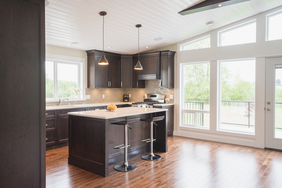 Large trendy u-shaped medium tone wood floor eat-in kitchen photo in Vancouver with an undermount sink, shaker cabinets, dark wood cabinets, quartzite countertops, gray backsplash, glass tile backsplash, stainless steel appliances and an island