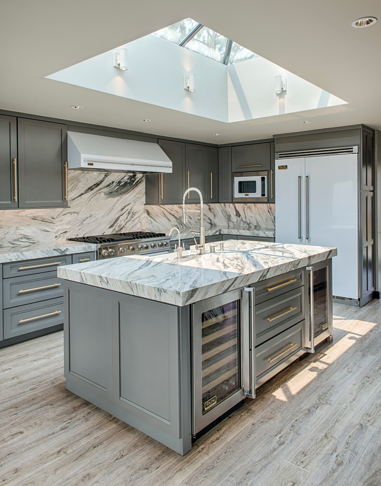 Trendy l-shaped kitchen photo in Los Angeles with recessed-panel cabinets, gray cabinets, multicolored backsplash, stone slab backsplash, white appliances and an island