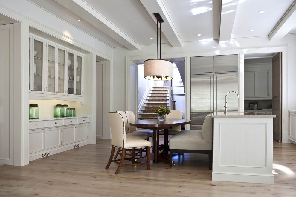 Inspiration for a mid-sized transitional u-shaped light wood floor and beige floor open concept kitchen remodel in Charlotte with an undermount sink, shaker cabinets, white cabinets, limestone countertops, white backsplash, wood backsplash, stainless steel appliances and an island