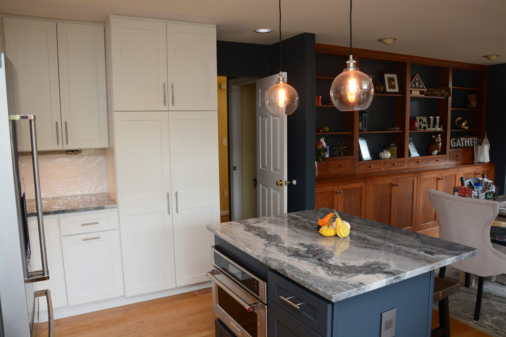 Exempel på ett mellanstort klassiskt kök, med en rustik diskho, luckor med infälld panel, vita skåp, granitbänkskiva, vitt stänkskydd, rostfria vitvaror, mellanmörkt trägolv, en köksö och brunt golv