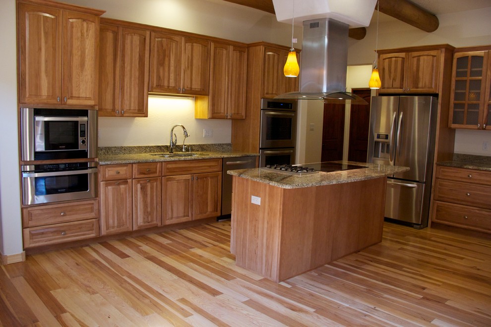 Mid-sized tuscan u-shaped medium tone wood floor kitchen photo in Albuquerque with an undermount sink, shaker cabinets, medium tone wood cabinets, granite countertops, stainless steel appliances and an island