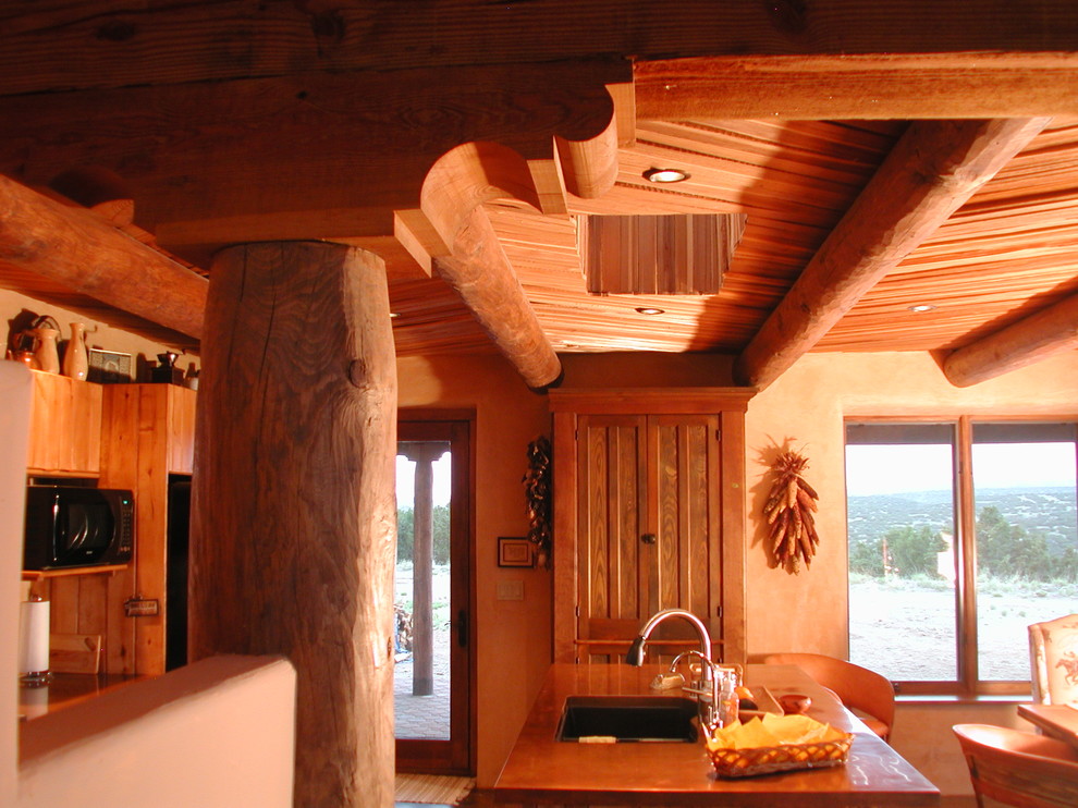 На фото: маленькая параллельная кухня в стиле фьюжн с обеденным столом, врезной мойкой, фасадами с декоративным кантом, светлыми деревянными фасадами, столешницей из меди, бетонным полом и островом для на участке и в саду