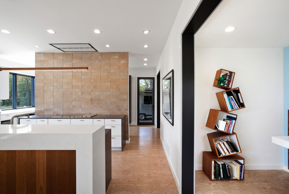 Exempel på ett mellanstort modernt kök, med en undermonterad diskho, släta luckor, vita skåp, bänkskiva i kvarts, orange stänkskydd, stänkskydd i glaskakel, rostfria vitvaror, korkgolv, en köksö och beiget golv