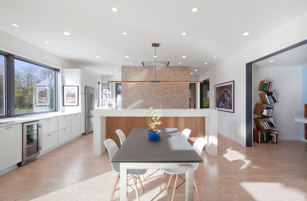 Exempel på ett mellanstort modernt kök, med en undermonterad diskho, släta luckor, vita skåp, bänkskiva i kvarts, orange stänkskydd, stänkskydd i glaskakel, rostfria vitvaror, korkgolv, en köksö och beiget golv