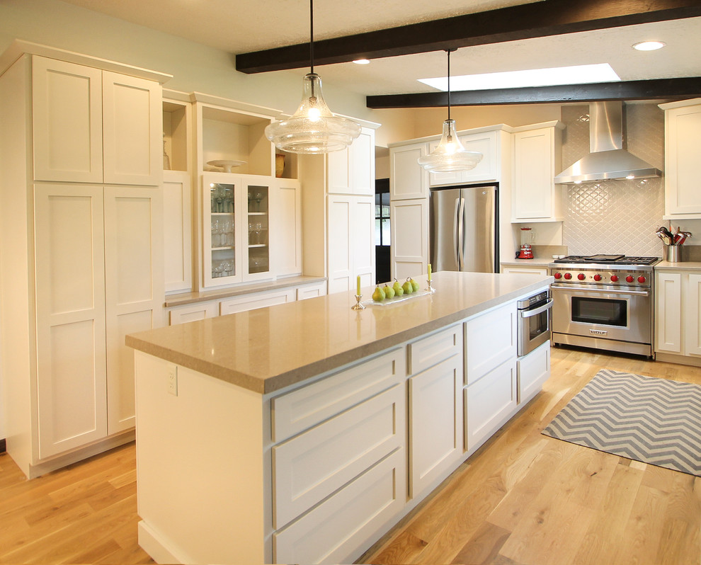 Example of a mid-sized minimalist u-shaped light wood floor eat-in kitchen design in Denver with shaker cabinets, white cabinets, quartz countertops, gray backsplash, ceramic backsplash, stainless steel appliances and an island