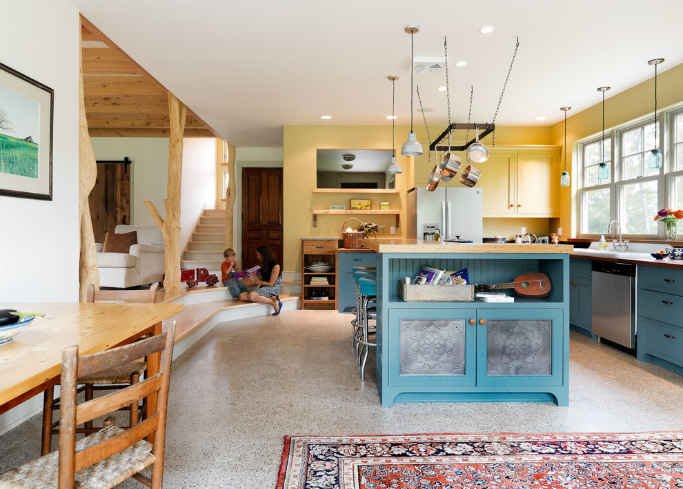 Urige Wohnküche in L-Form mit blauen Schränken, Arbeitsplatte aus Holz, Kücheninsel, Einbauwaschbecken und Küchengeräten aus Edelstahl in Burlington