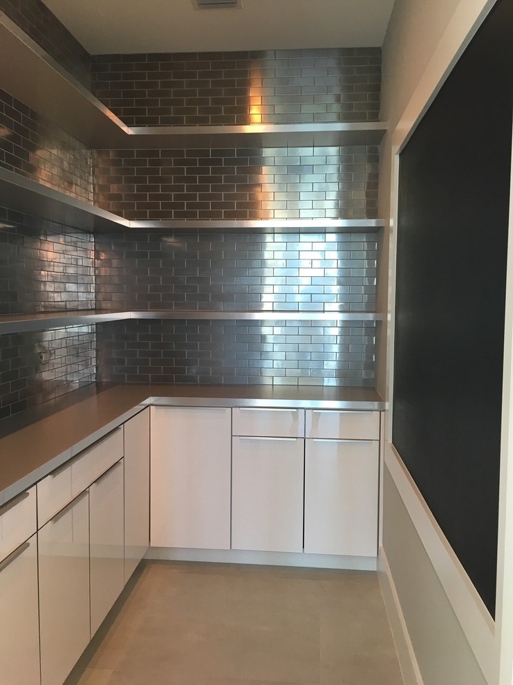 Inspiration for a small contemporary l-shaped concrete floor kitchen pantry remodel in Miami with flat-panel cabinets, white cabinets, stainless steel countertops, metallic backsplash, subway tile backsplash and an island
