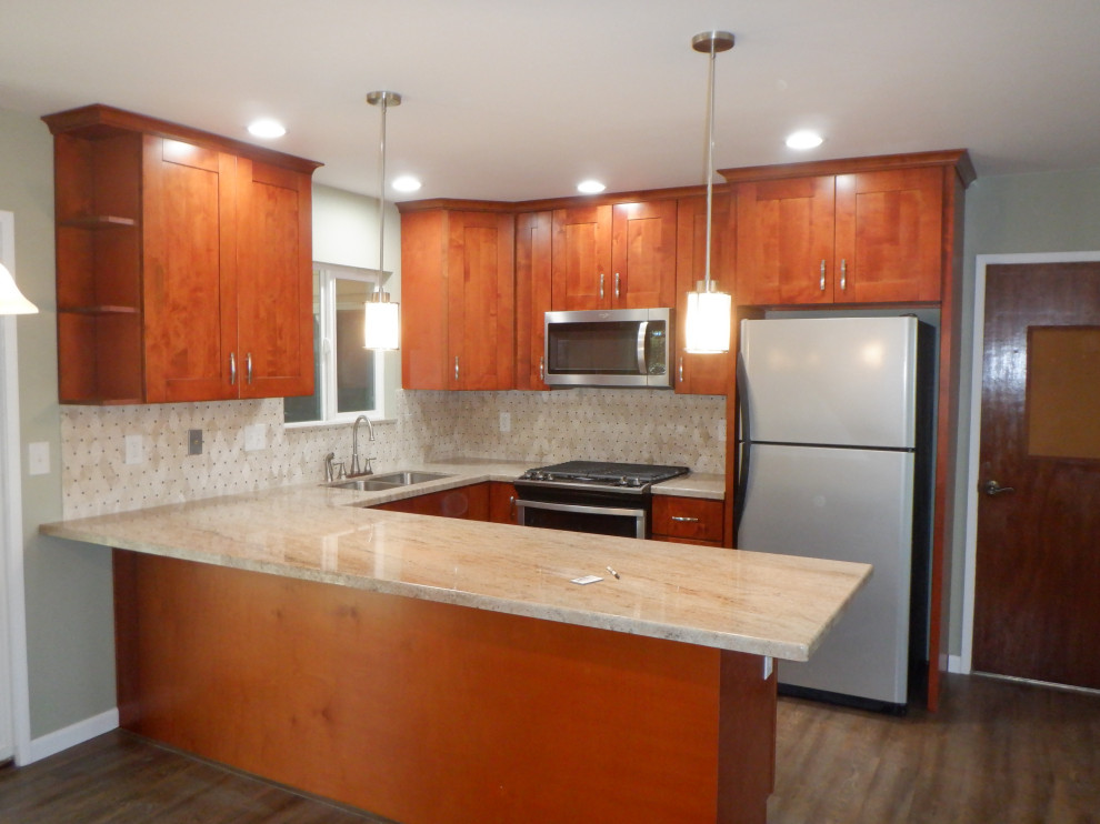 Photo of a medium sized classic u-shaped kitchen/diner in San Diego with a submerged sink, shaker cabinets, red cabinets, granite worktops, beige splashback, stainless steel appliances, medium hardwood flooring, a breakfast bar, brown floors and beige worktops.
