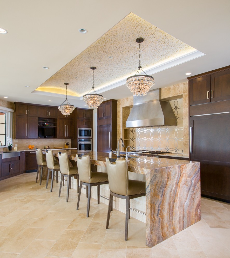 Example of a trendy l-shaped beige floor kitchen design in DC Metro with a farmhouse sink, shaker cabinets, dark wood cabinets, beige backsplash, paneled appliances and an island