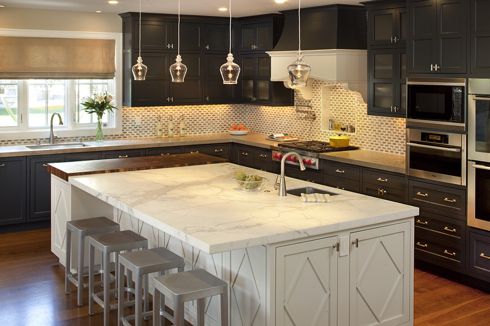 This is an example of a classic kitchen in San Francisco with stainless steel appliances, recessed-panel cabinets, dark wood cabinets, marble worktops and limestone splashback.