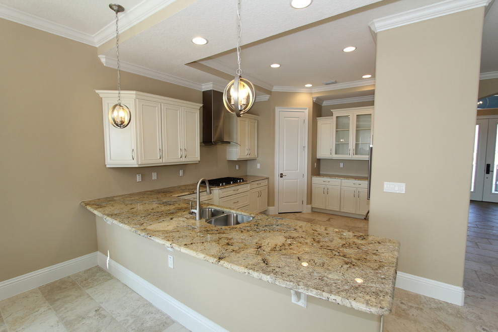 Design ideas for a large mediterranean u-shaped open plan kitchen in Orlando with a submerged sink, raised-panel cabinets, white cabinets, granite worktops, stainless steel appliances, an island, beige floors and ceramic flooring.