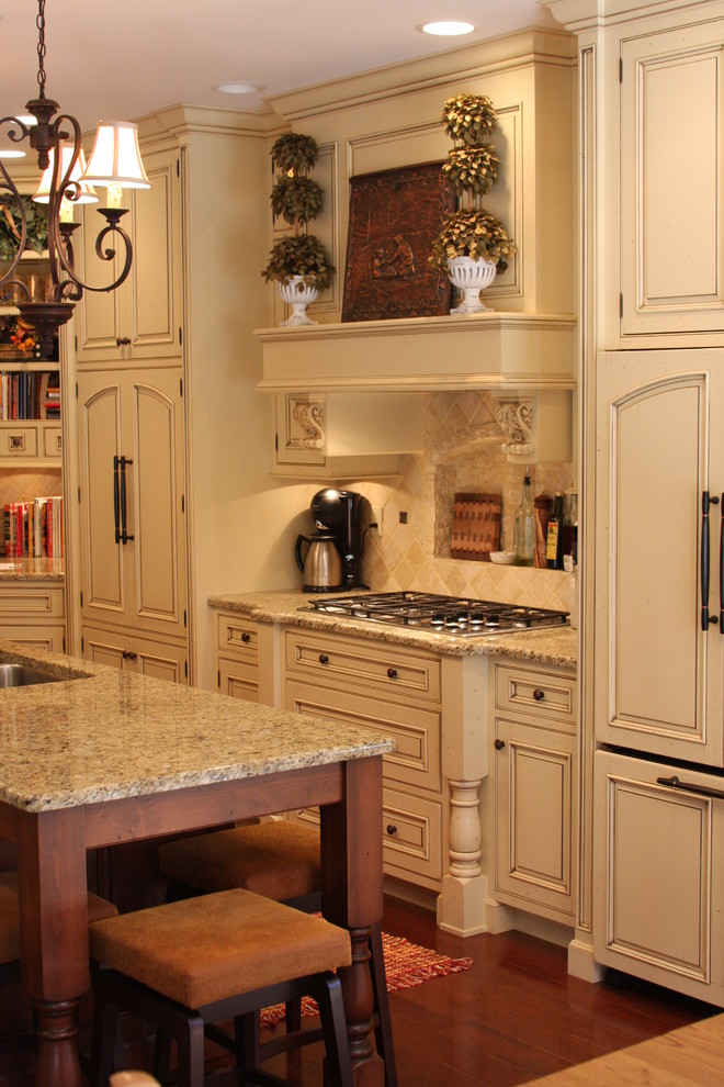 Exempel på ett klassiskt kök, med luckor med infälld panel, vita skåp, granitbänkskiva, beige stänkskydd, stänkskydd i stenkakel, mellanmörkt trägolv och en köksö