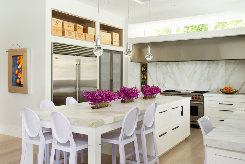 Exempel på ett avskilt, stort modernt u-kök, med en undermonterad diskho, luckor med infälld panel, vita skåp, marmorbänkskiva, vitt stänkskydd, rostfria vitvaror, ljust trägolv och en köksö