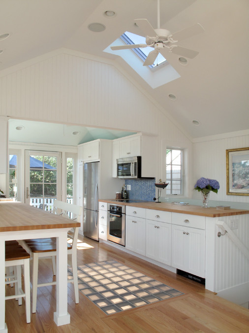 Bild på ett mellanstort funkis kök, med luckor med lamellpanel, vita skåp, träbänkskiva, blått stänkskydd, stänkskydd i stickkakel, rostfria vitvaror, mellanmörkt trägolv och brunt golv