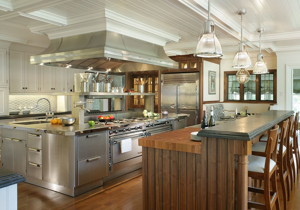 Huge ornate medium tone wood floor eat-in kitchen photo in New York with beaded inset cabinets, stainless steel cabinets, metallic backsplash, stainless steel appliances, a drop-in sink, metal backsplash, two islands and stainless steel countertops