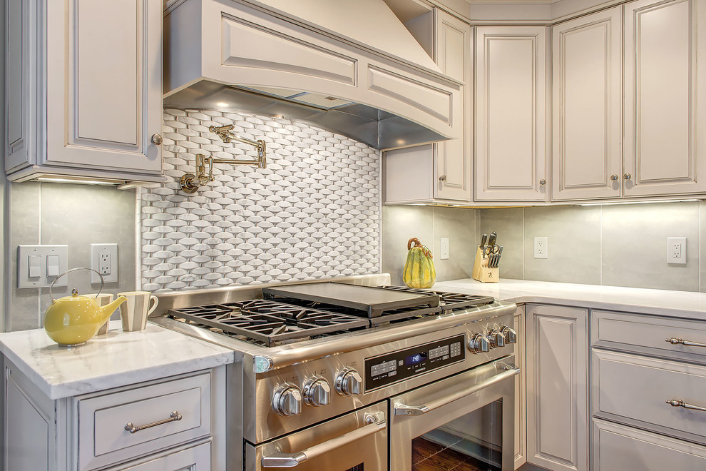 Inspiration for a transitional l-shaped eat-in kitchen remodel in Minneapolis with an undermount sink, gray cabinets, marble countertops, gray backsplash, porcelain backsplash and stainless steel appliances