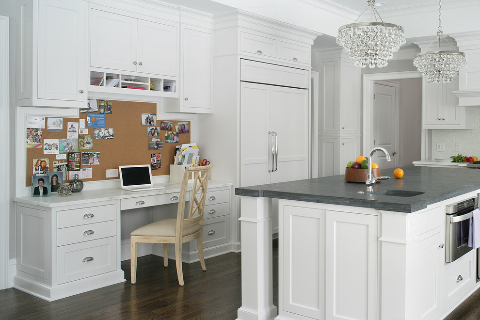Exempel på ett klassiskt u-kök, med en integrerad diskho, skåp i shakerstil, vita skåp, integrerade vitvaror, mörkt trägolv och en köksö