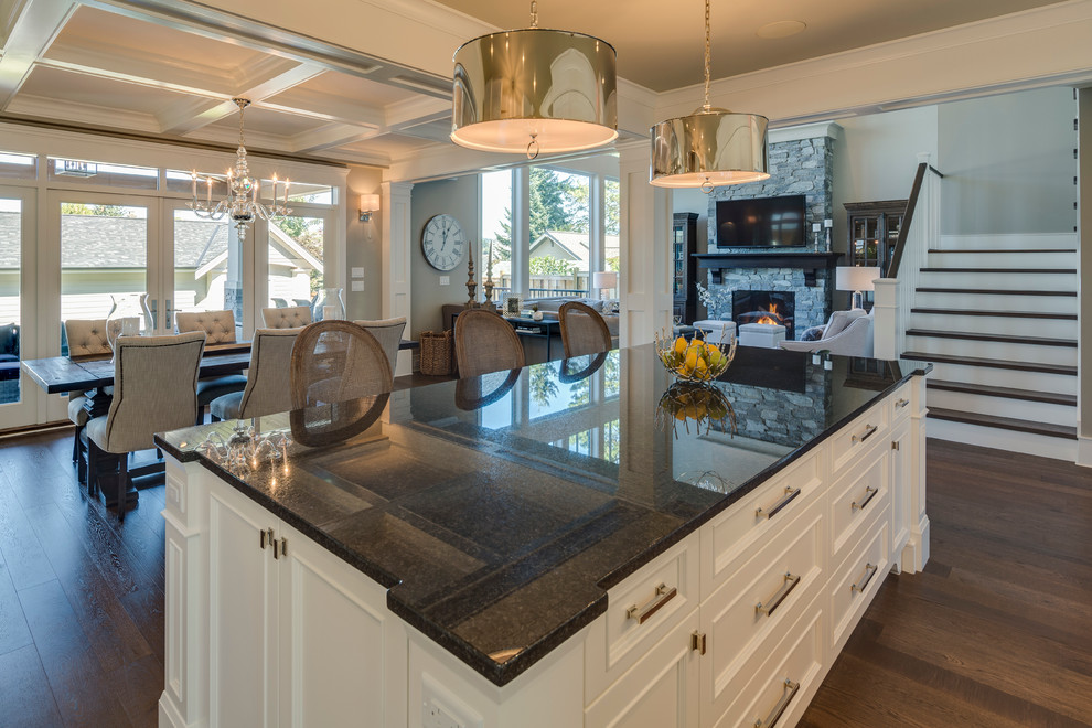 Photo of a medium sized traditional l-shaped kitchen/diner in Vancouver with recessed-panel cabinets, white cabinets, granite worktops, medium hardwood flooring and an island.