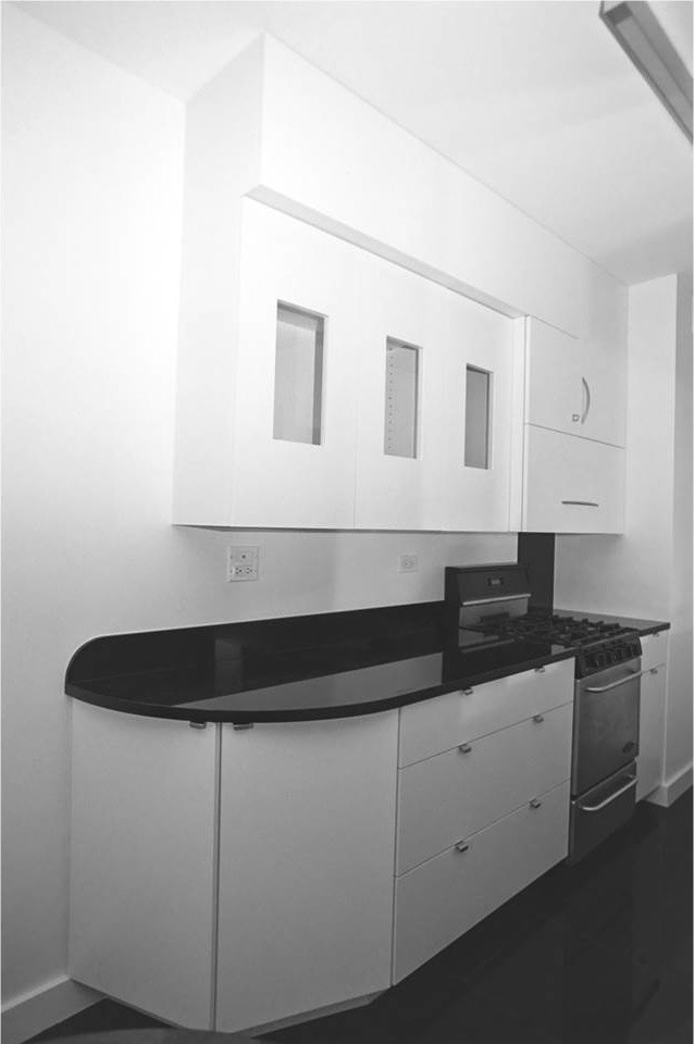 Immagine di una piccola cucina moderna con ante lisce, ante bianche, top in granito, paraspruzzi con lastra di vetro, elettrodomestici bianchi, lavello sottopiano e penisola