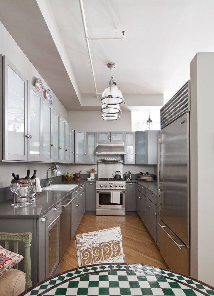 Transitional u-shaped kitchen photo in New York with gray cabinets