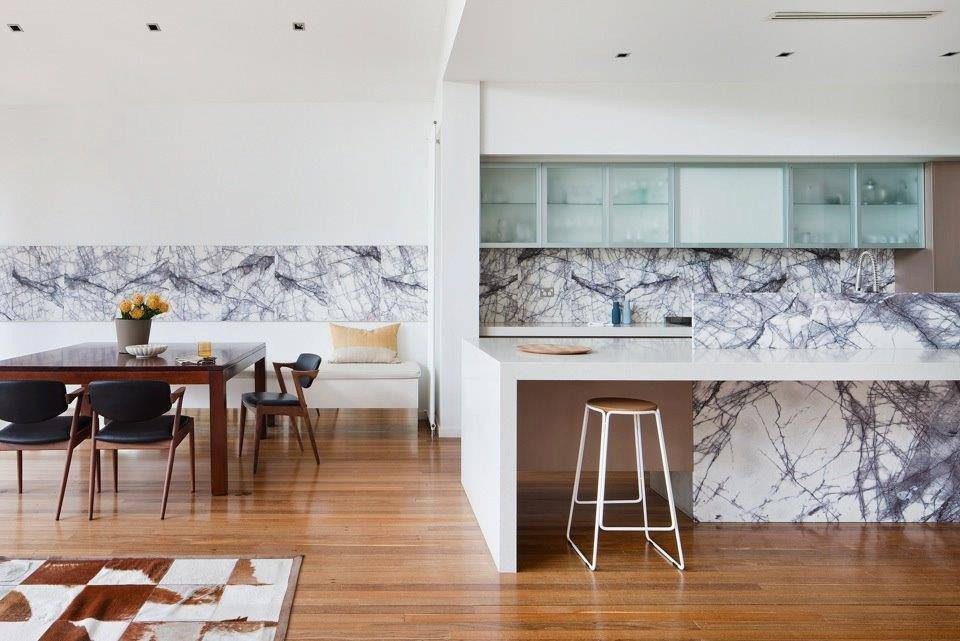 Immagine di una cucina design con ante di vetro, ante bianche, top in quarzo composito, paraspruzzi multicolore, paraspruzzi in marmo, pavimento in legno massello medio e top bianco