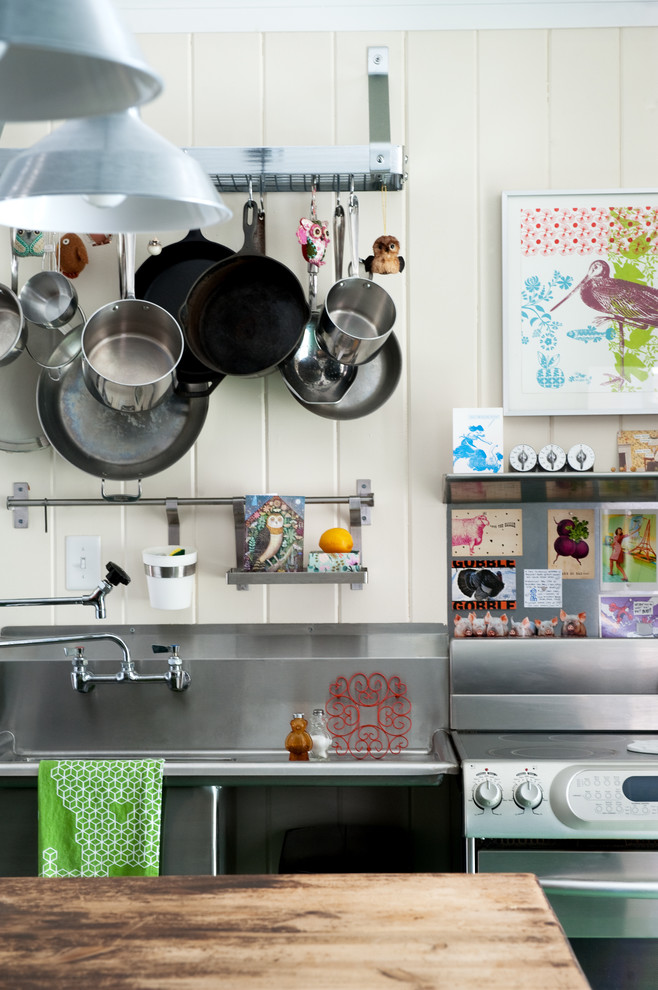 На фото: кухня в стиле фьюжн с монолитной мойкой, столешницей из нержавеющей стали и техникой из нержавеющей стали