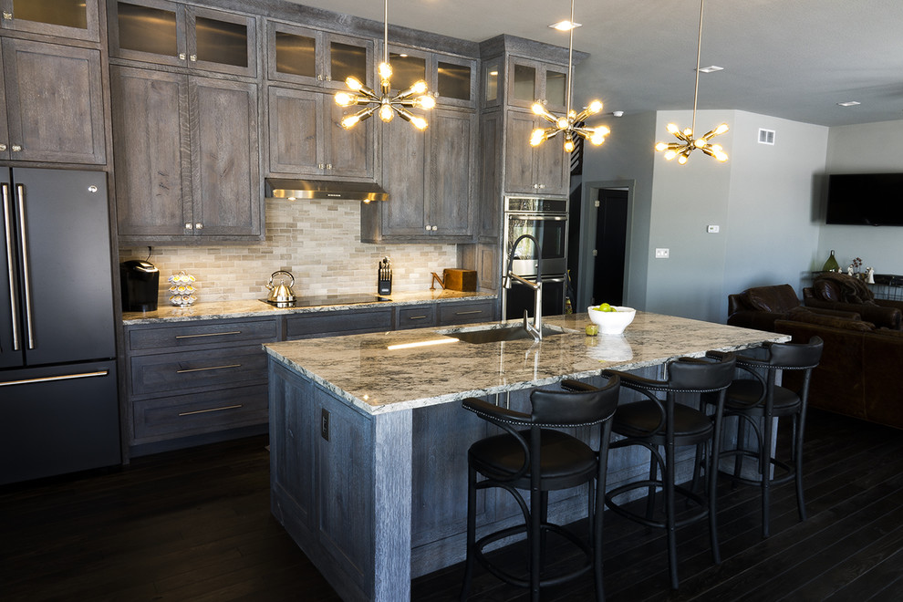 Example of a mid-sized urban single-wall dark wood floor and black floor open concept kitchen design in Other with an undermount sink, recessed-panel cabinets, distressed cabinets, granite countertops, gray backsplash, ceramic backsplash, stainless steel appliances and an island