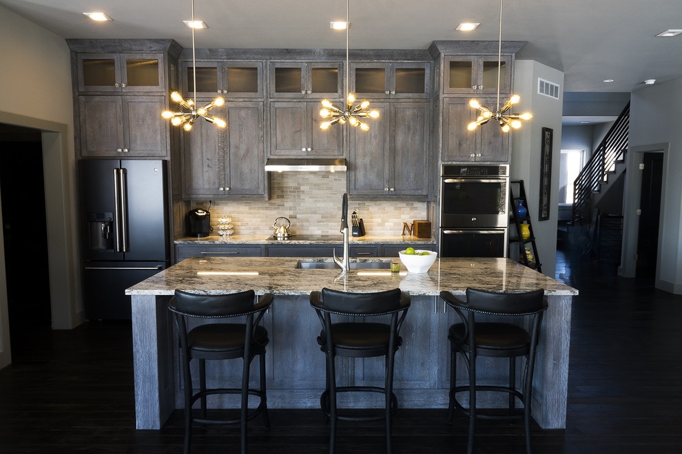 Foto på ett mellanstort industriellt linjärt kök med öppen planlösning, med en undermonterad diskho, luckor med infälld panel, skåp i slitet trä, granitbänkskiva, beige stänkskydd, stänkskydd i keramik, rostfria vitvaror, mörkt trägolv, en köksö och svart golv