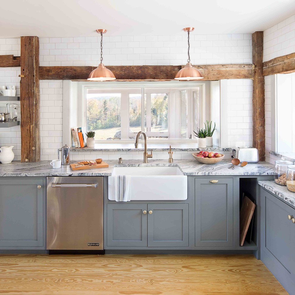 Exempel på ett lantligt l-kök, med en rustik diskho, släta luckor, grå skåp, marmorbänkskiva, vitt stänkskydd, stänkskydd i tunnelbanekakel, rostfria vitvaror och plywoodgolv