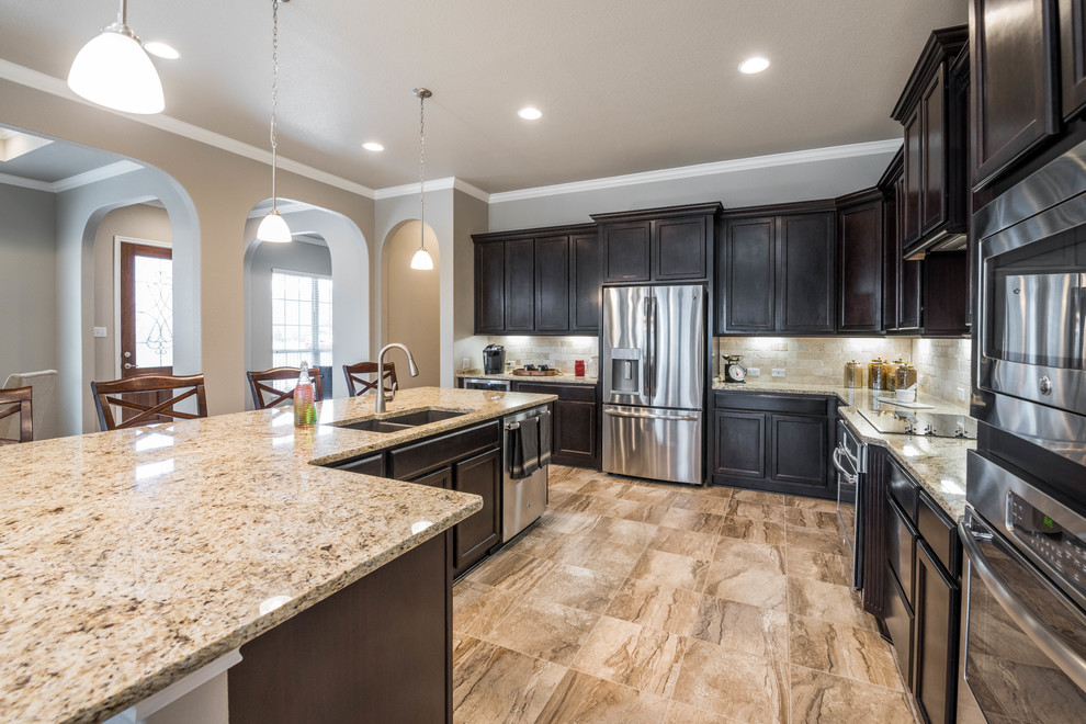 Bild på ett mellanstort amerikanskt flerfärgad flerfärgat kök, med luckor med infälld panel, skåp i mörkt trä, granitbänkskiva, beige stänkskydd, stänkskydd i stenkakel, rostfria vitvaror, klinkergolv i keramik, en köksö och flerfärgat golv