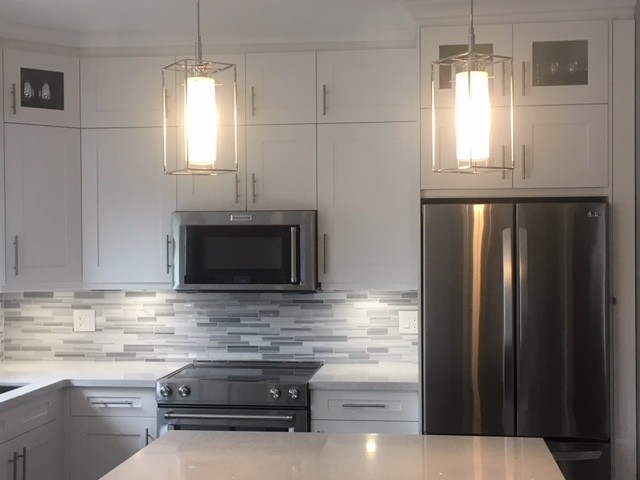 Inspiration for a medium sized classic l-shaped kitchen/diner in Toronto with a submerged sink, shaker cabinets, white cabinets, quartz worktops, grey splashback, mosaic tiled splashback, stainless steel appliances, porcelain flooring, an island, grey floors and white worktops.
