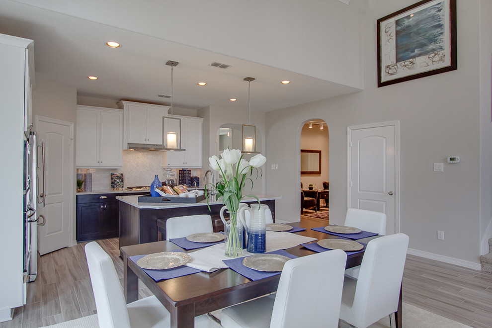 Example of a trendy l-shaped open concept kitchen design in Houston with a farmhouse sink, granite countertops, white backsplash, stainless steel appliances and an island