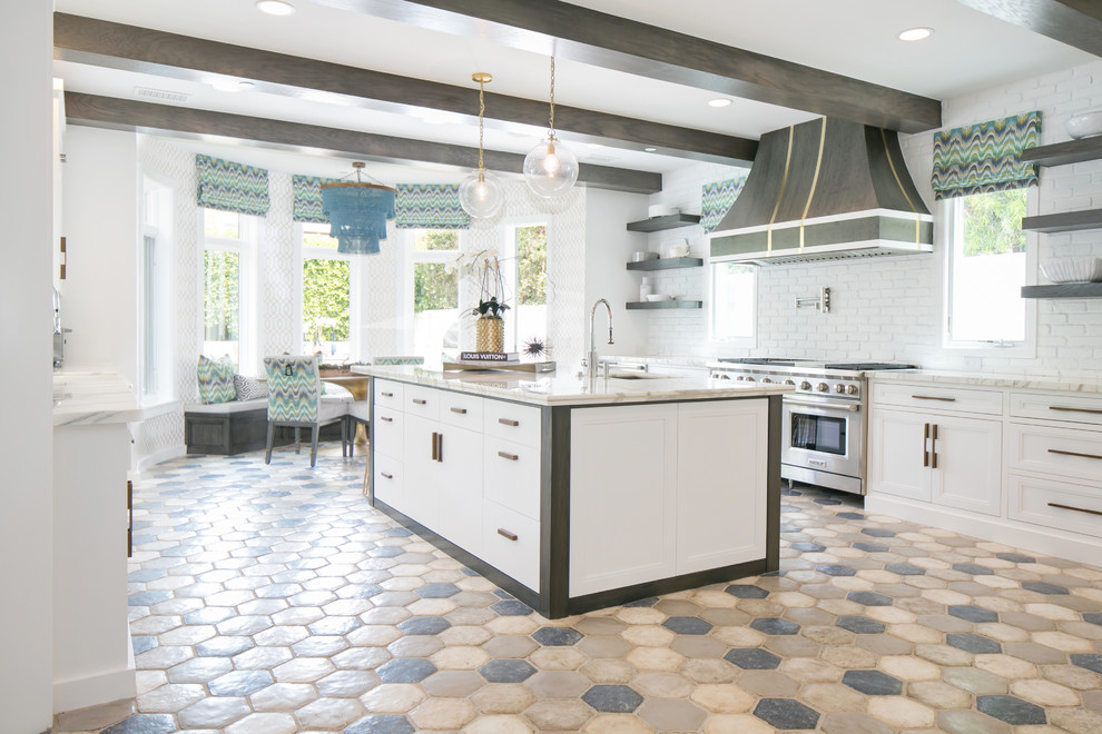 Inspiration for a large traditional kitchen/diner in Orange County with recessed-panel cabinets, white cabinets, marble worktops, white splashback, metro tiled splashback, stainless steel appliances, terracotta flooring and an island.